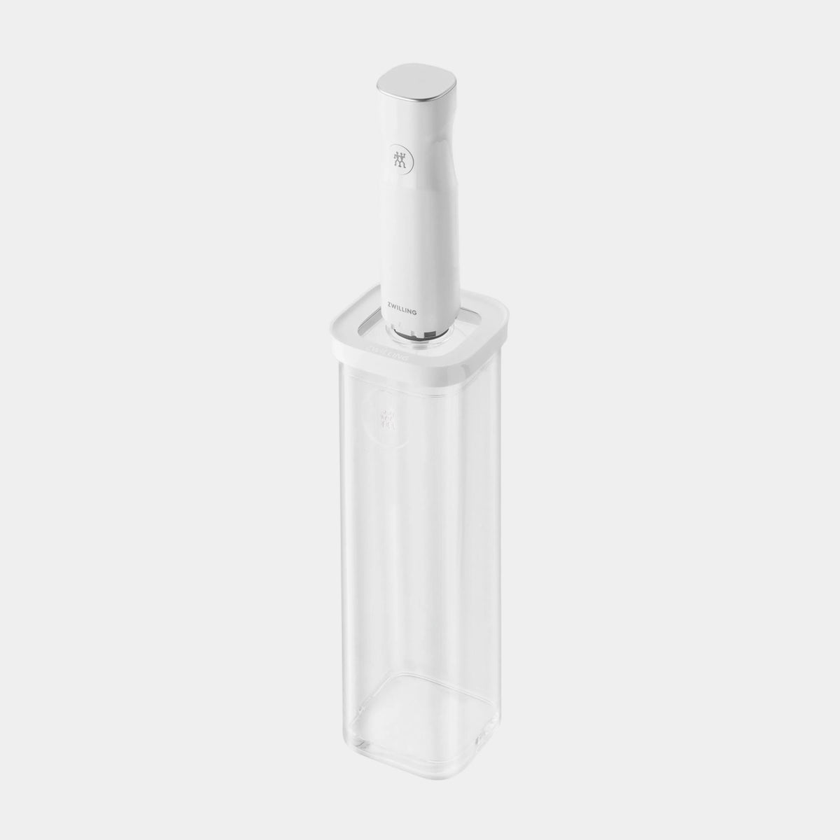 A white electric meat tenderizer with a silver-toned textured tip, shown standing upright inside a clear plastic storage container on a plain white background.