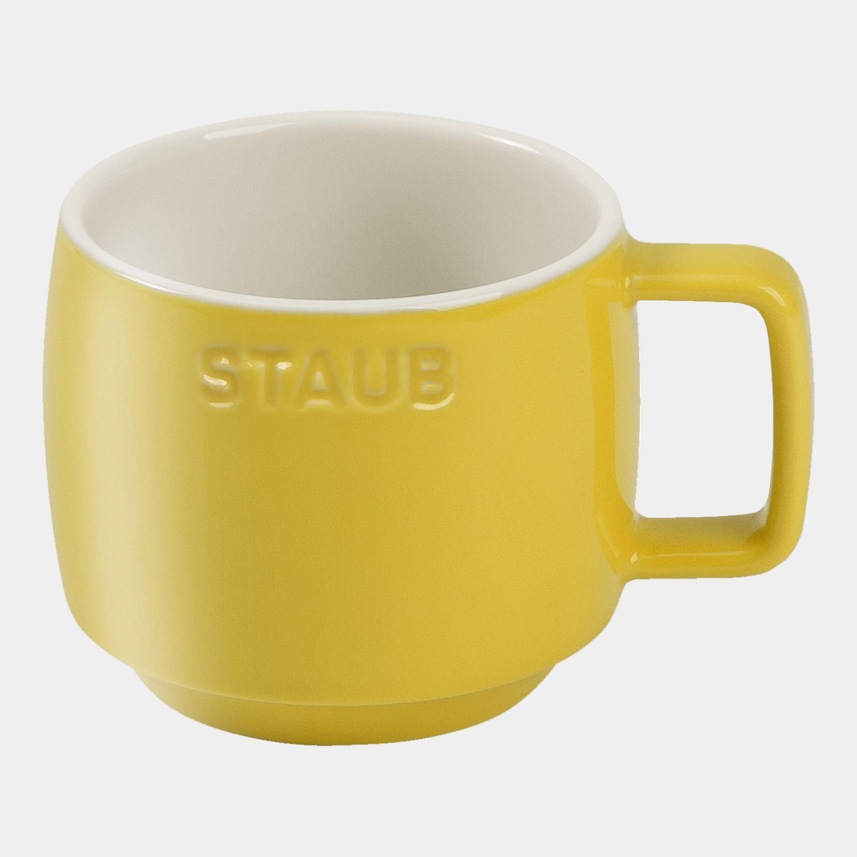 Yellow mug with white interior on a white background, featuring the Staub logo.
