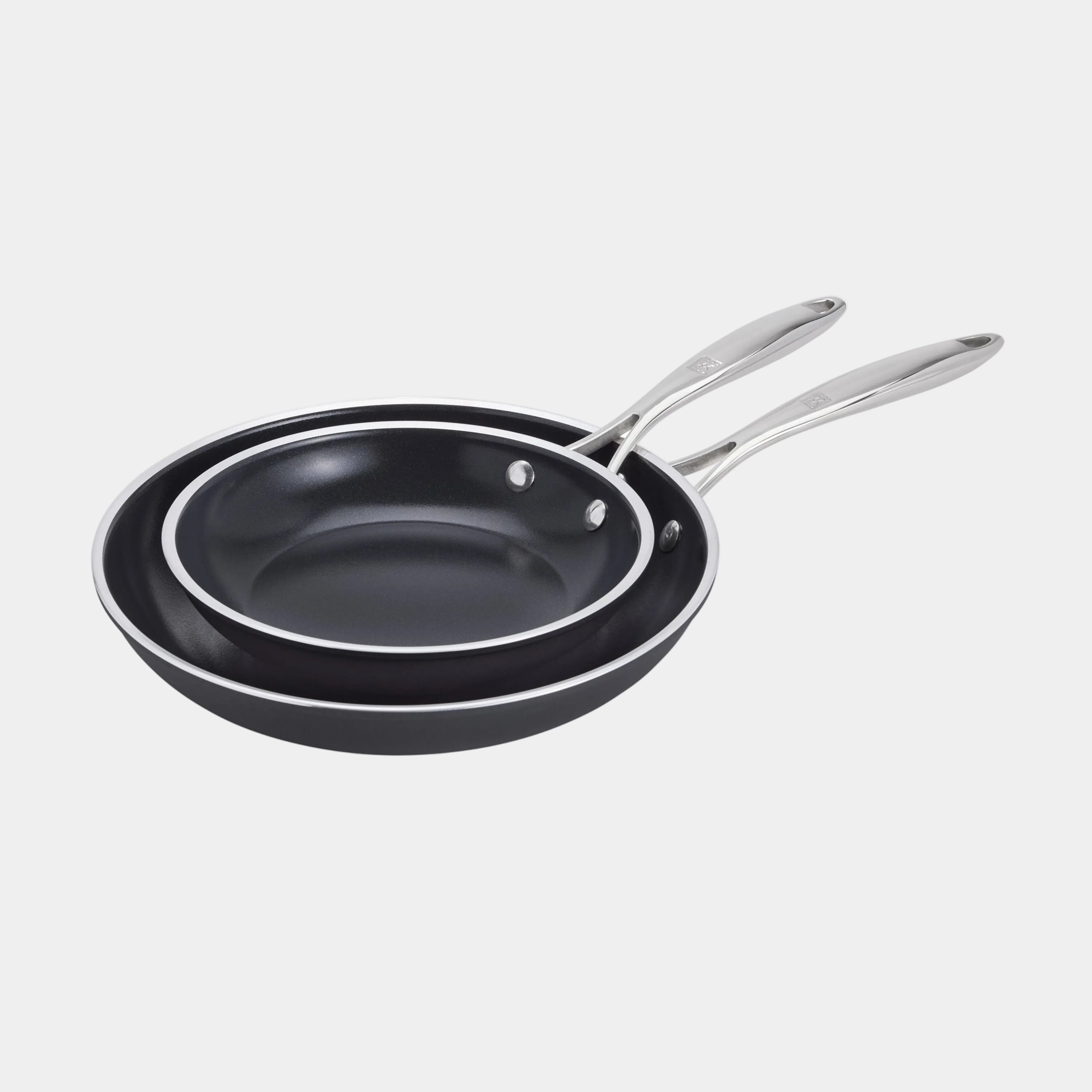 Set of two black frying pans with silver handles on a white background