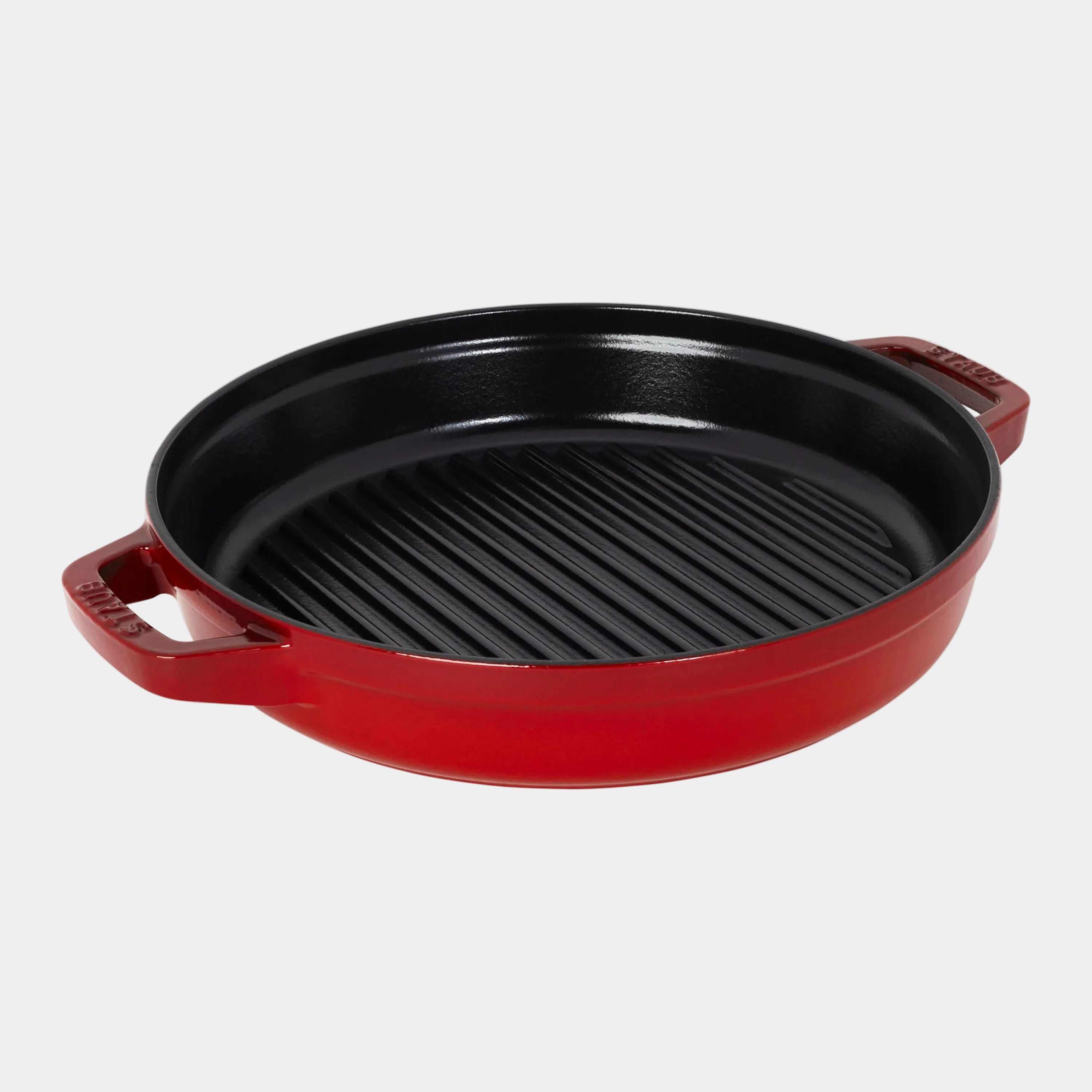 Red cast iron skillet with a black interior on a white background
