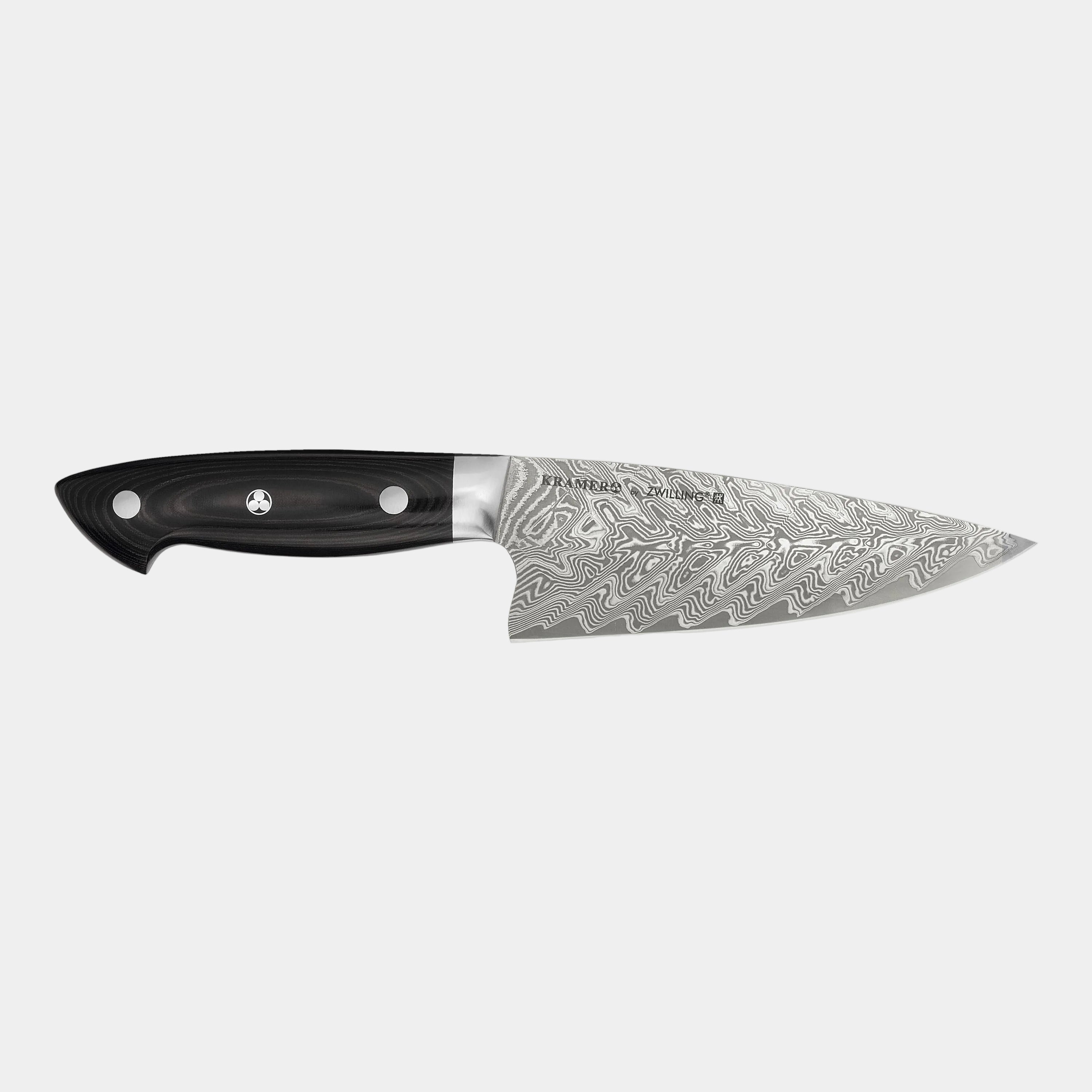 Chef's knife with a black handle and decorative blade on a white background