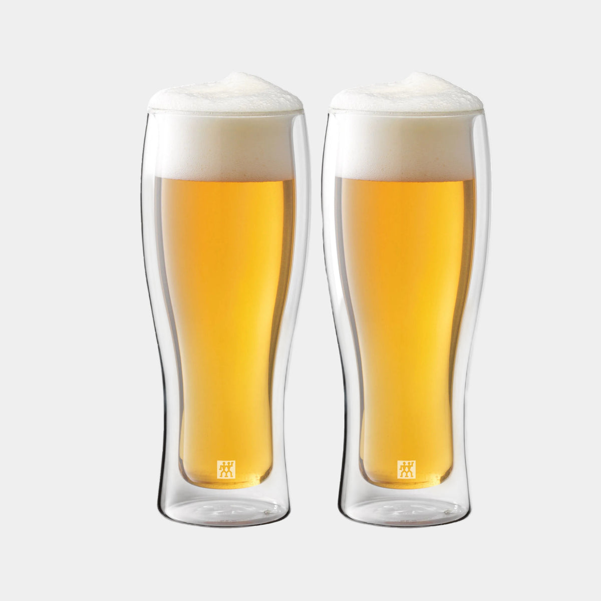 Two clear glass beer mugs filled with beer on a white background