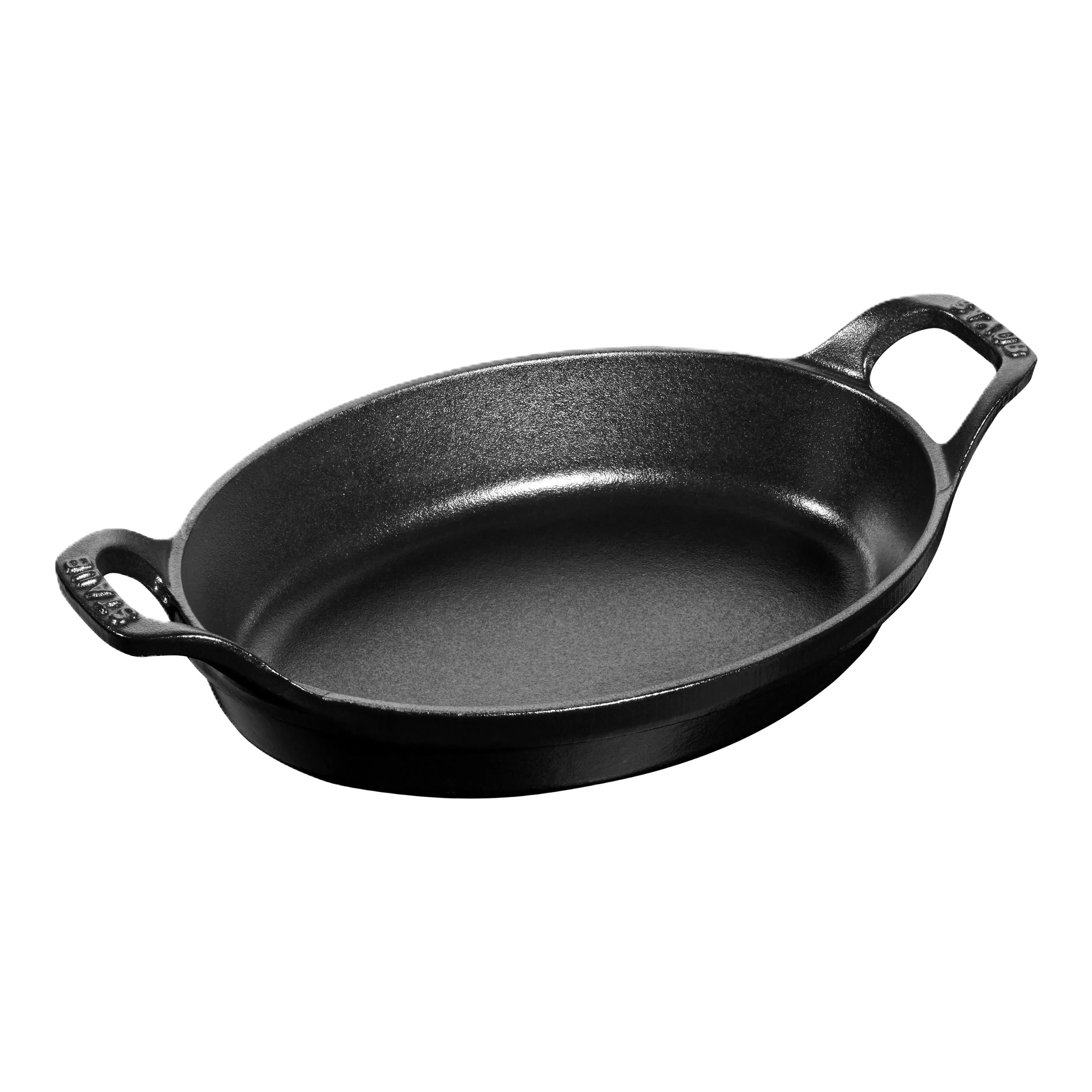 Black cast iron oval skillet with handles on a white background