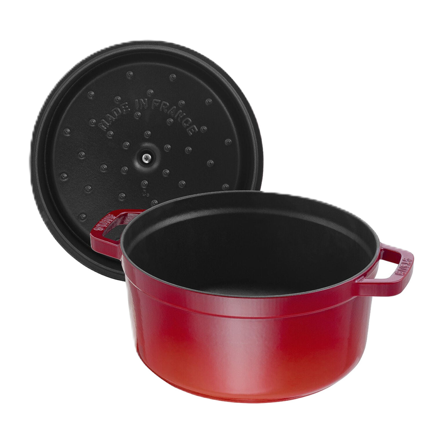 Red enameled cast iron Dutch oven with black lid on a white background