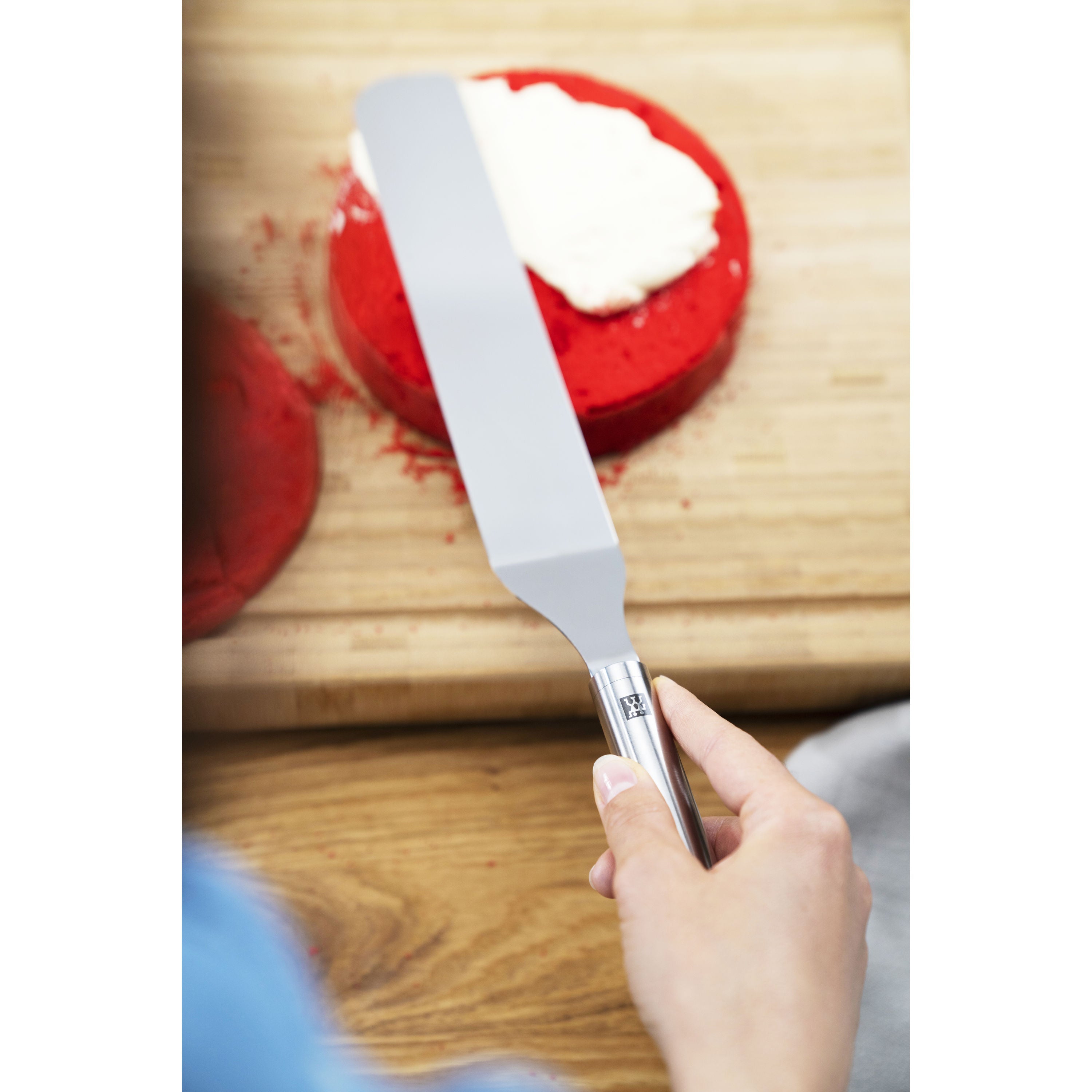 ZWILLING Pro Icing Spatula in use, spreading cream on a red cake.