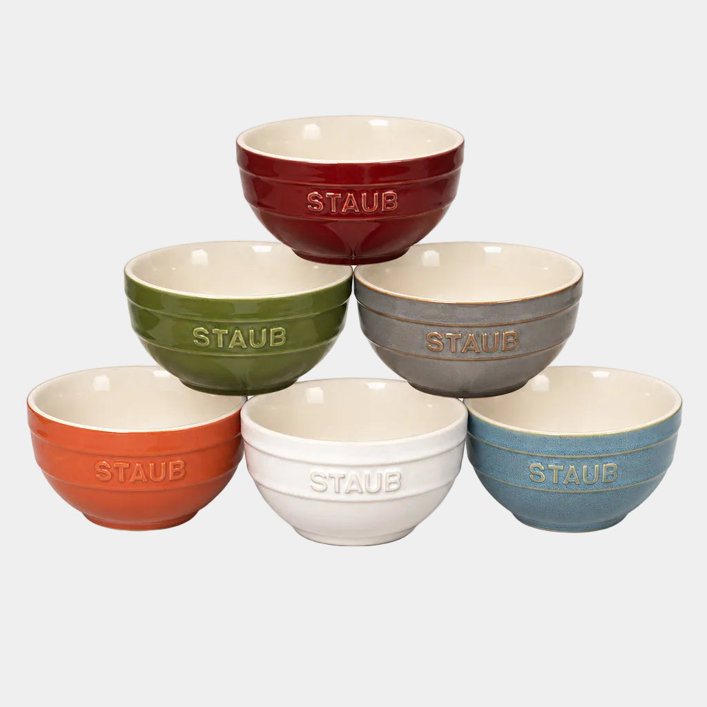 Set of six Staub ceramic bowls in different colors on a white background