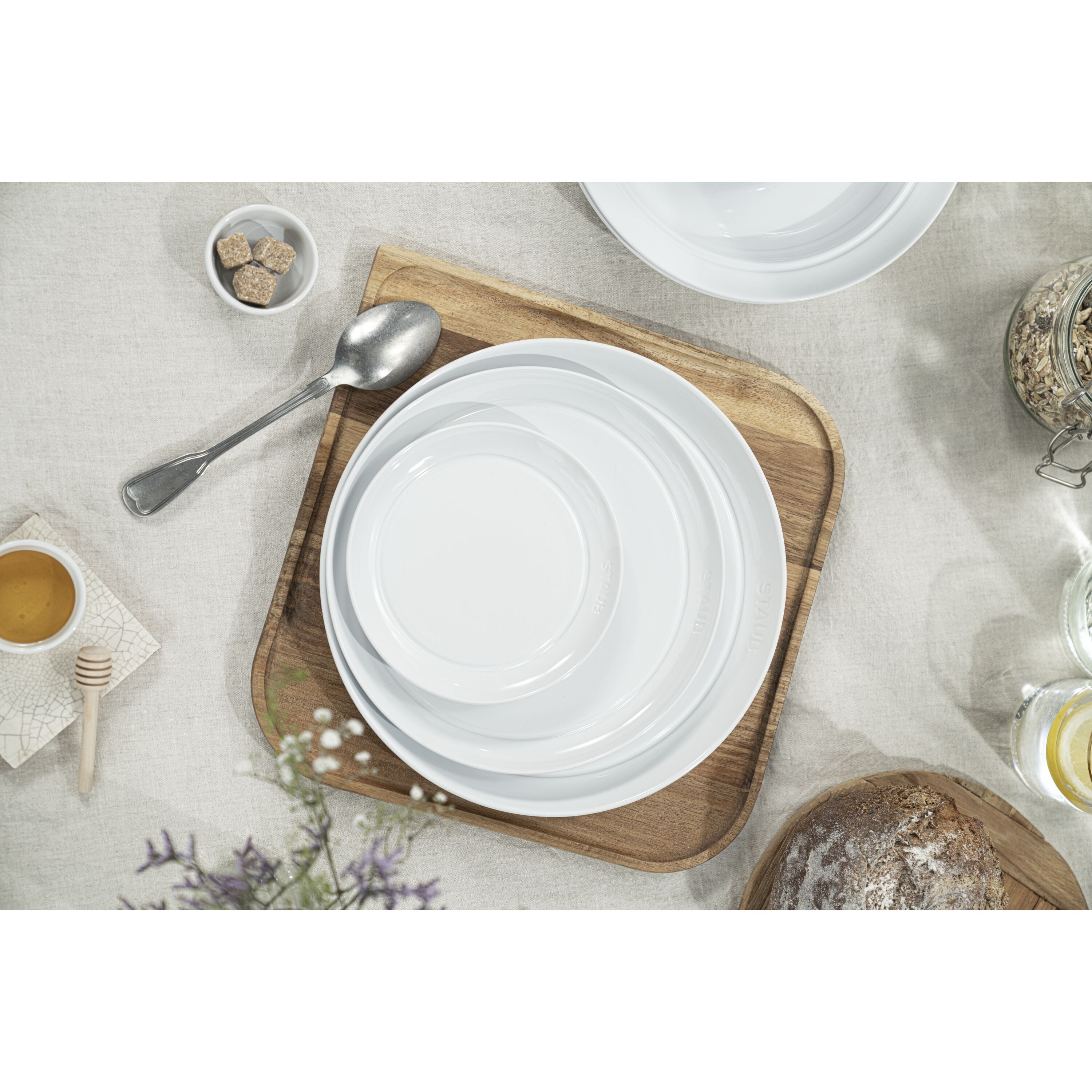 White ceramic plates on a wooden cutting board with a neutral background