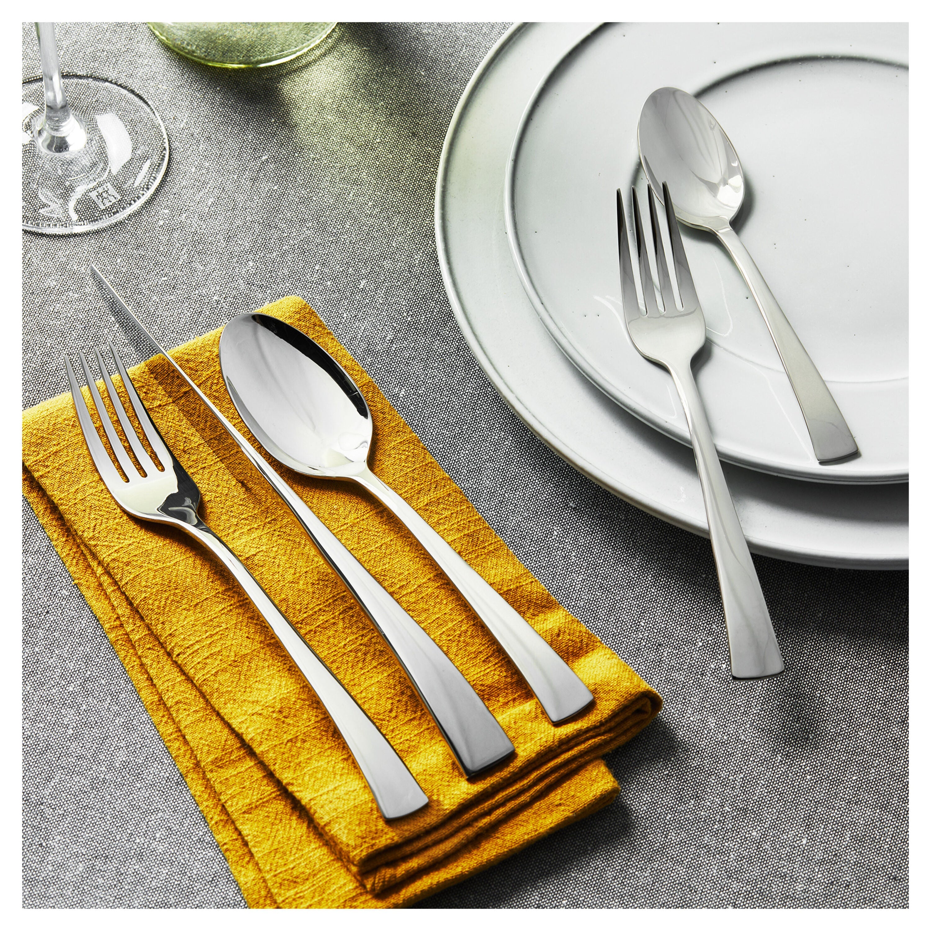 ZWILLING Bellasera 45 Pcs Flatware Set on table with napkin and plates