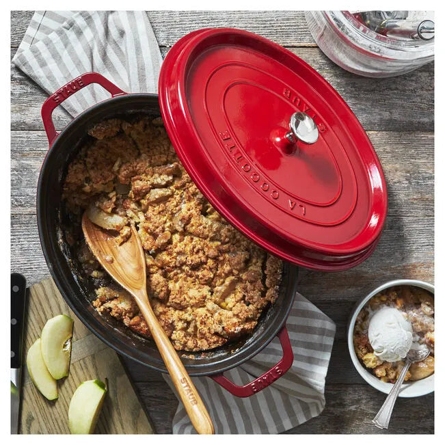Red Dutch oven with apple crumble on a wooden table