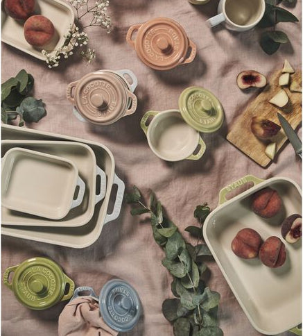 STAUB Macaron Baker Set Rectangular in a charming French-inspired design with assorted dishes and peaches on a rustic table setting.