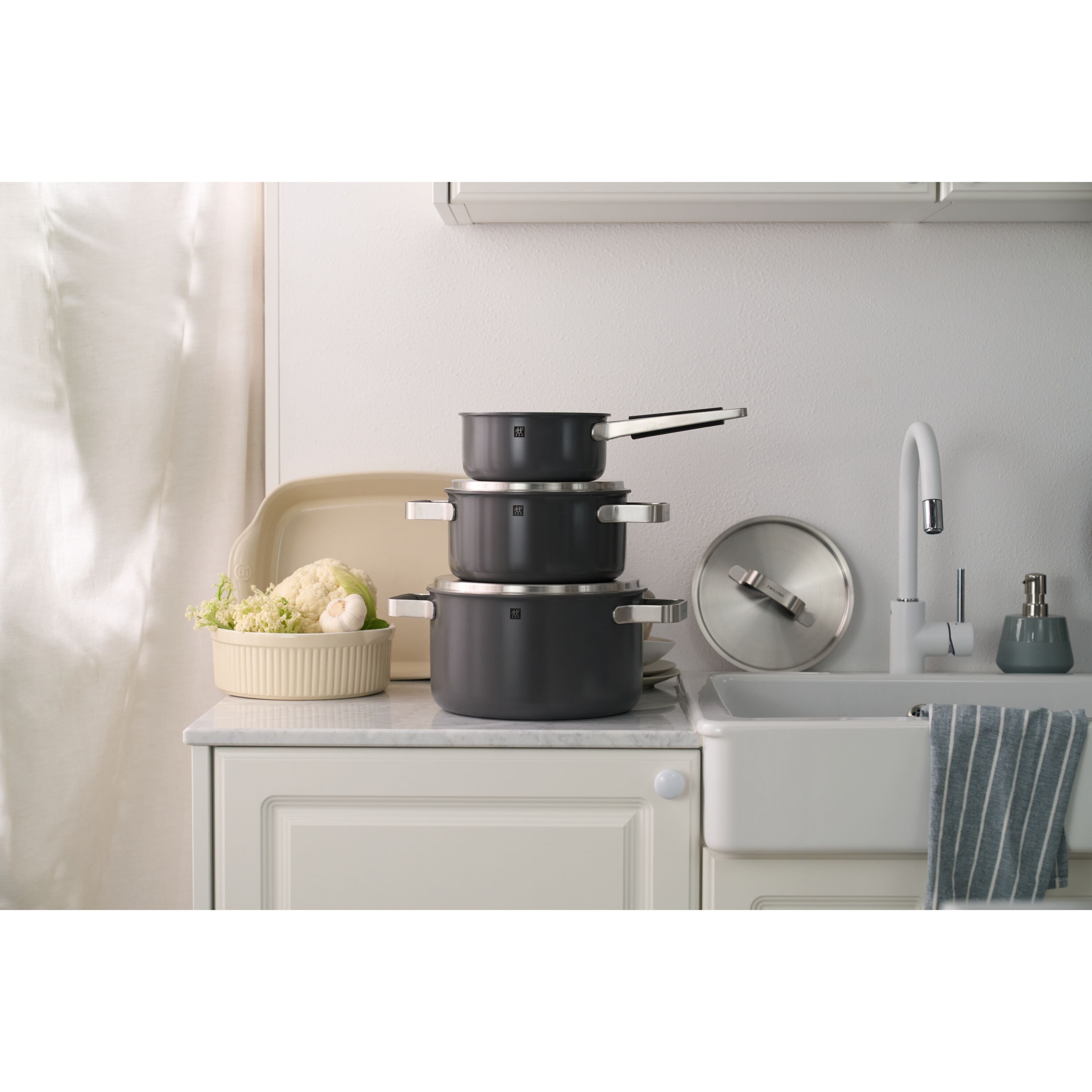 Set of black cookware on a kitchen counter with a neutral background