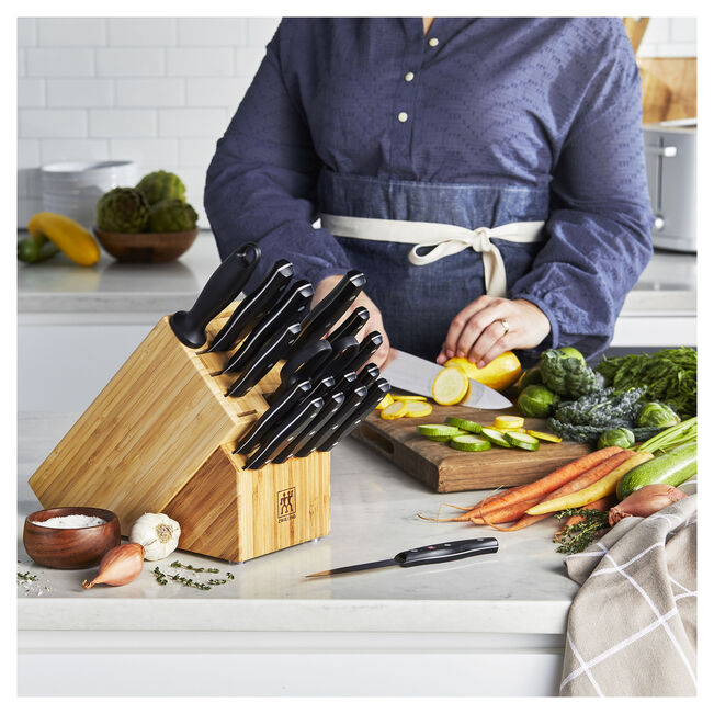 ZWILLING TWIN Signature 19 Piece Knife Block Set displayed with fresh vegetables and a cutting board.
