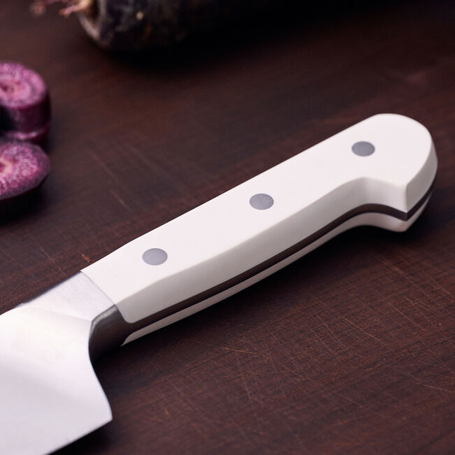 White kitchen knife with black handle on a wooden surface