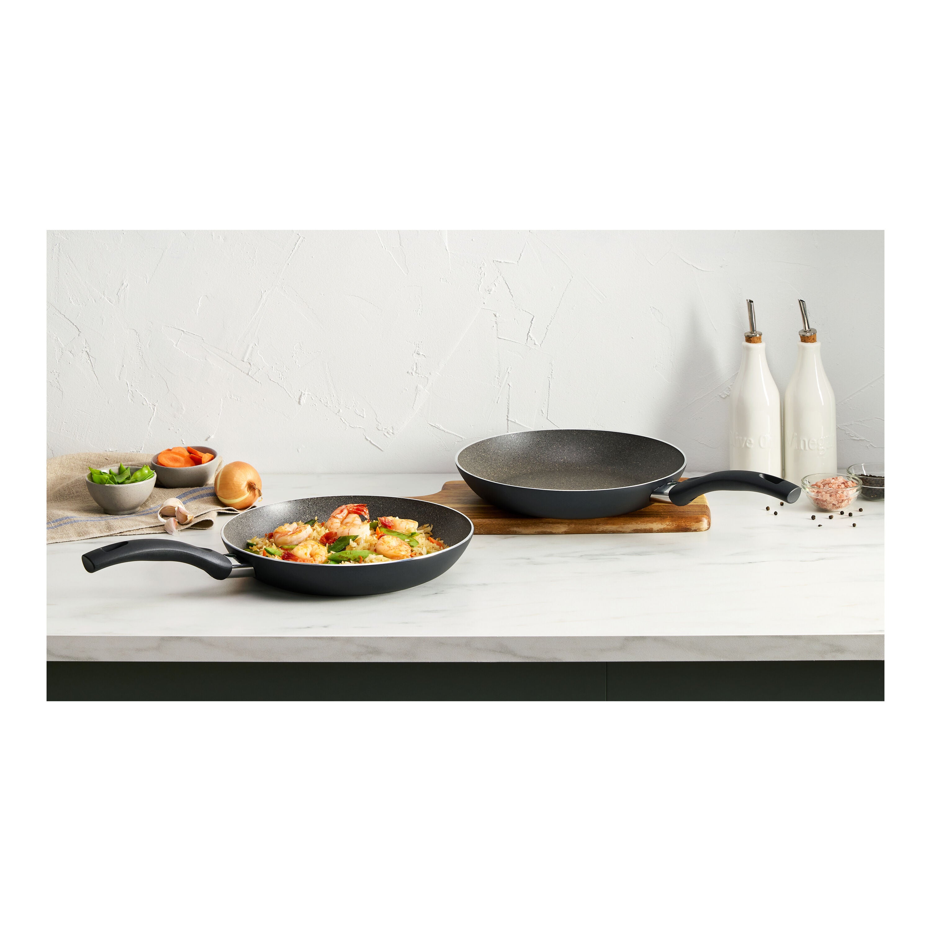 ZWILLING Bologna Granitium Aluminum Fry Pan set displayed on a kitchen countertop with vegetables.