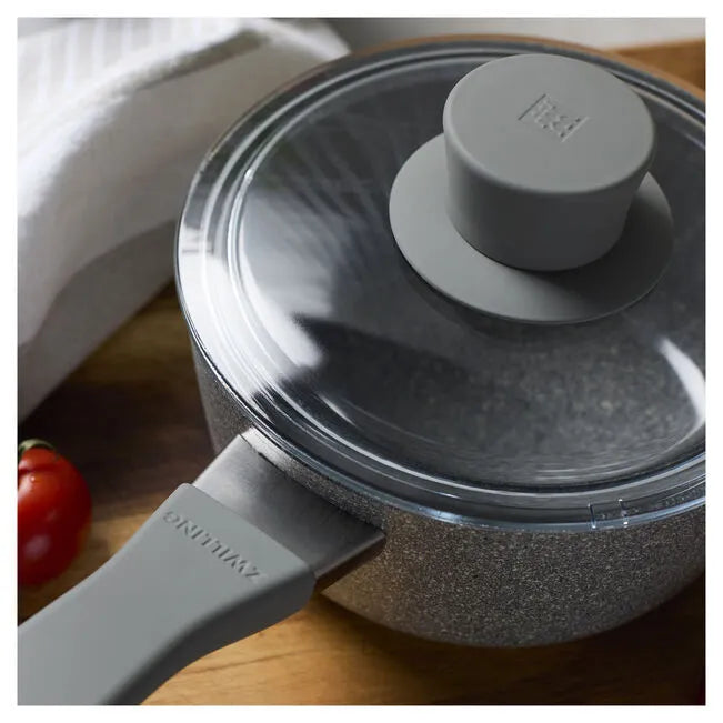 Gray cookware set with lid on a wooden surface