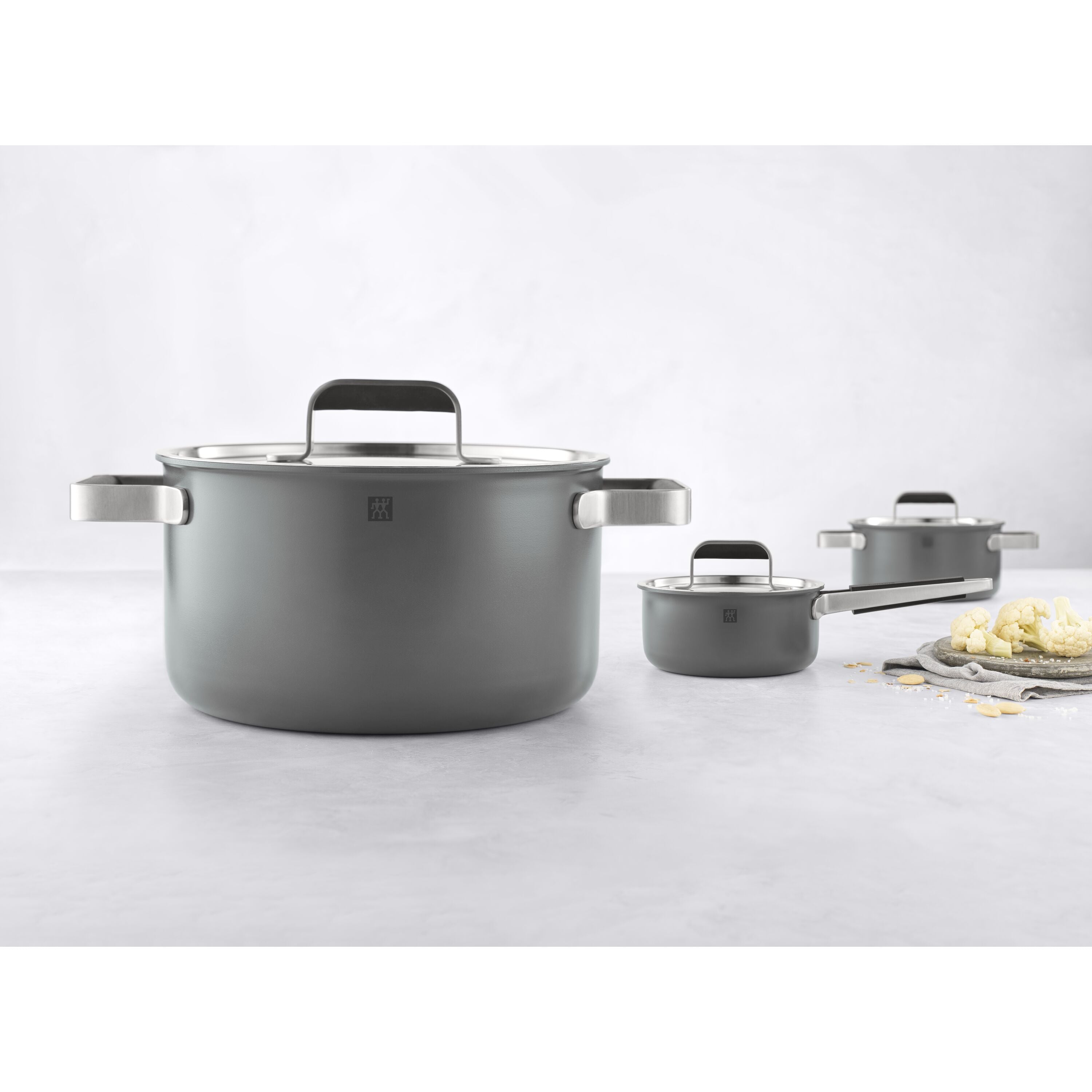 Set of gray cookware with black handles on a white background