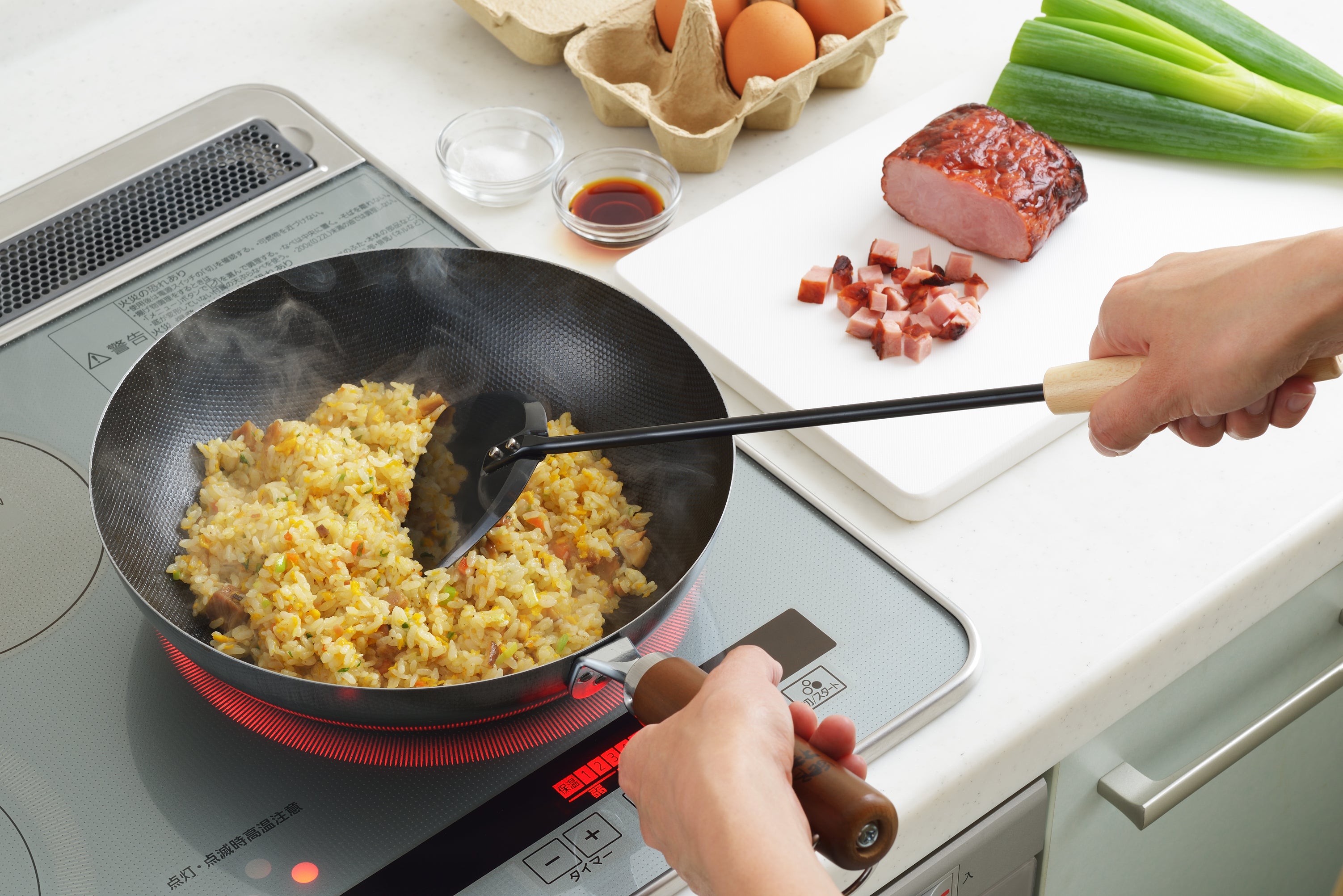 Cooking fried rice with Yoshikawa Cook-Pal Chinese Metal Spatula on stovetop, showcasing durable iron plate and wooden handle.