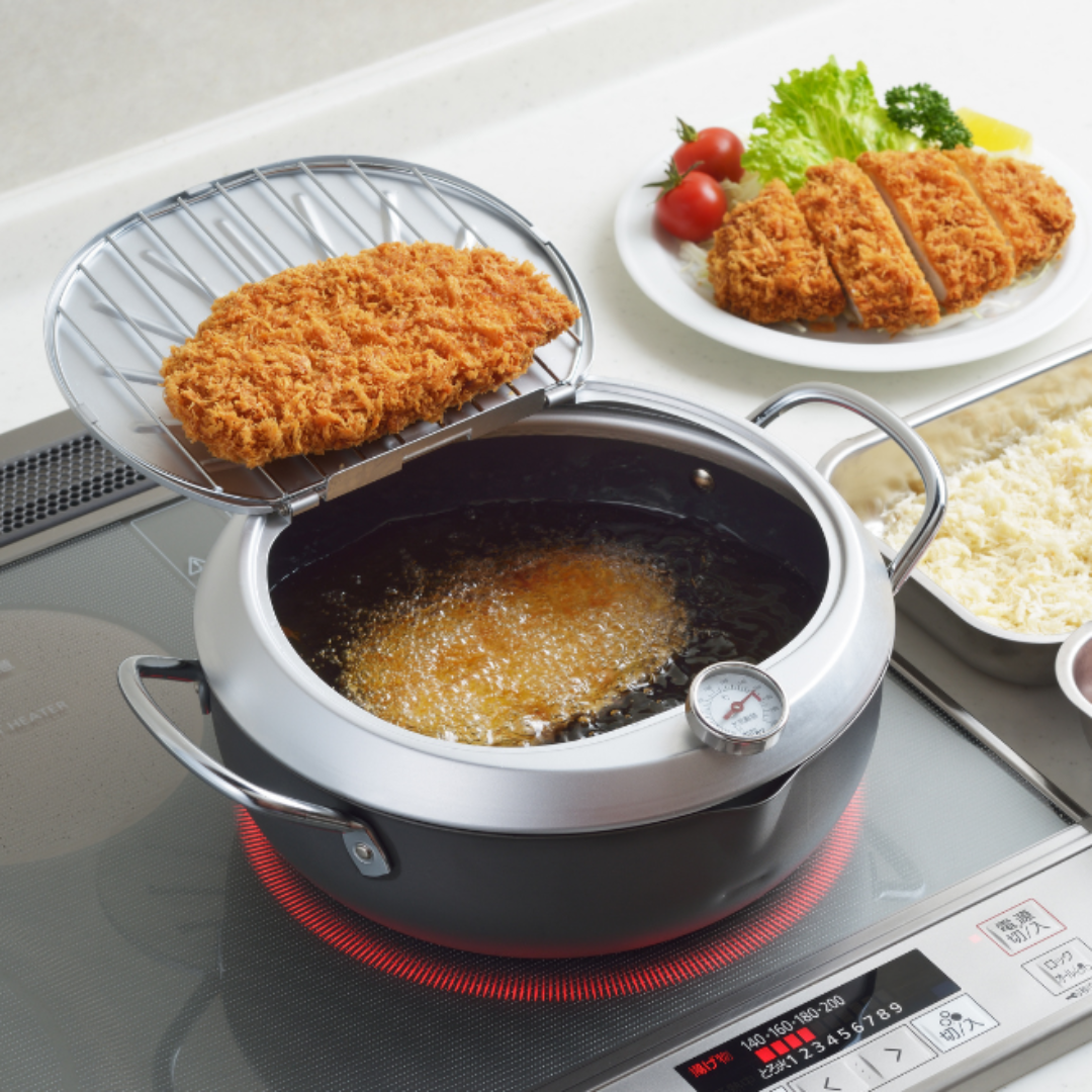 YOSHIKAWA GOGI Tempura Pot 24 cm with food on a stove, surrounded by ingredients and a plate of prepared dishes.