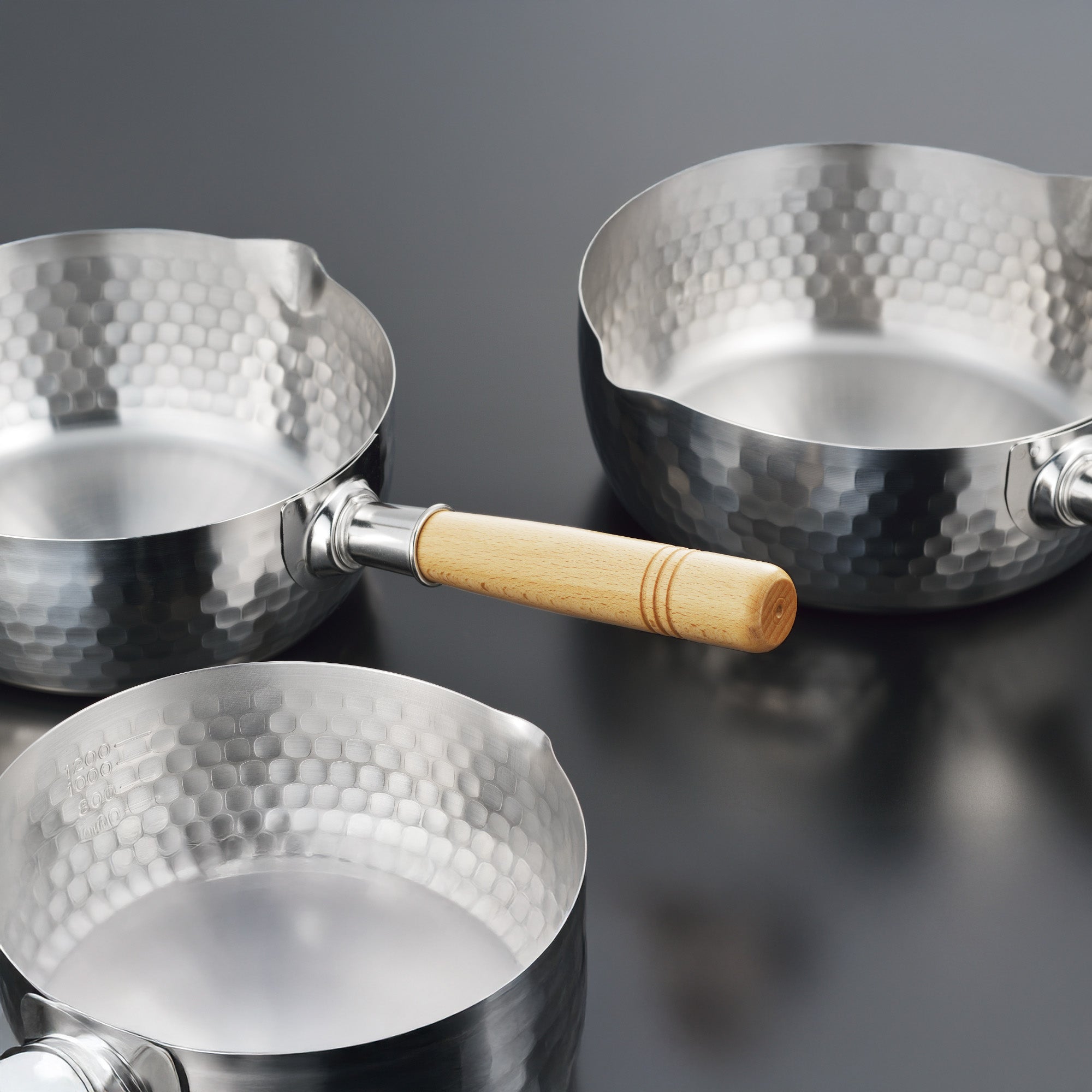 Yoshikawa Yukihira Saucepan set featuring three handcrafted stainless steel pots with hammered exterior.