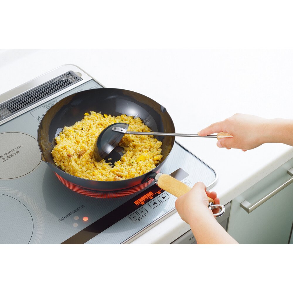 Person cooking scrambled eggs in a frying pan on an electric stove withYoshikawa Cook-Pal Chinese Ladle.