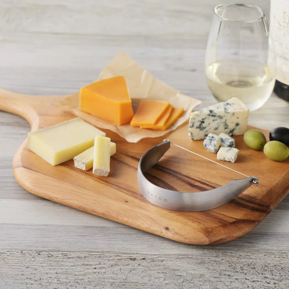 EAtoCO Kaku Wire Cheese Cutter on wooden board with assorted cheeses and wine