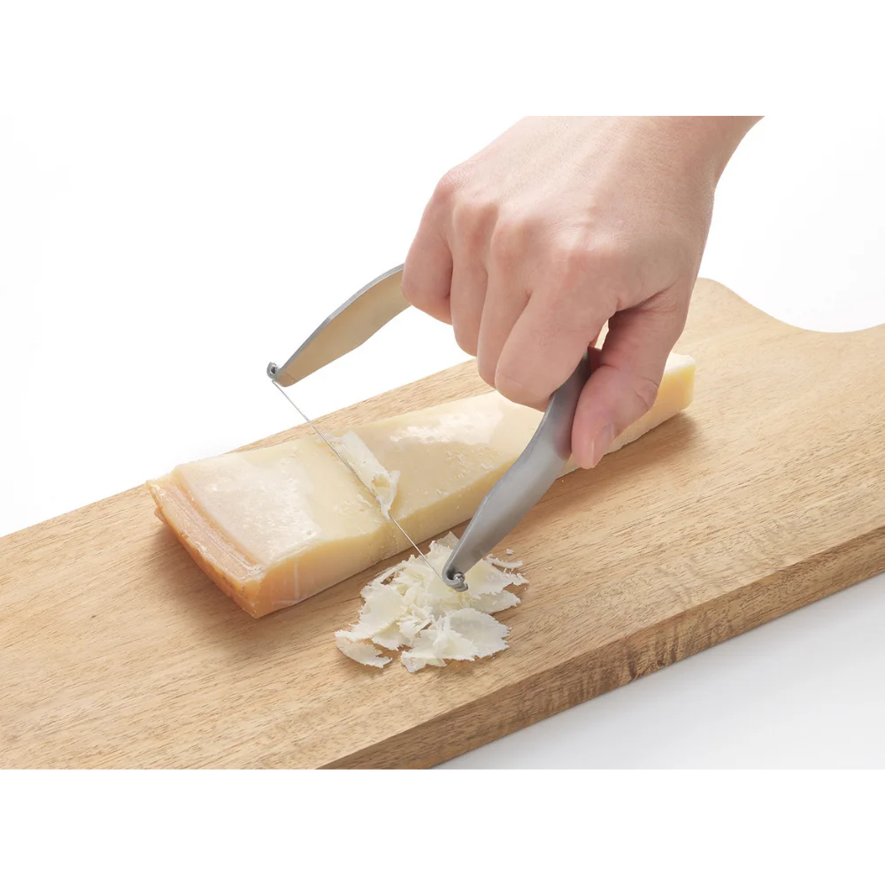 EAtoCO Kaku Wire Cheese Cutter slicing cheese on a wooden board, showcasing clean cutting without sticking.
